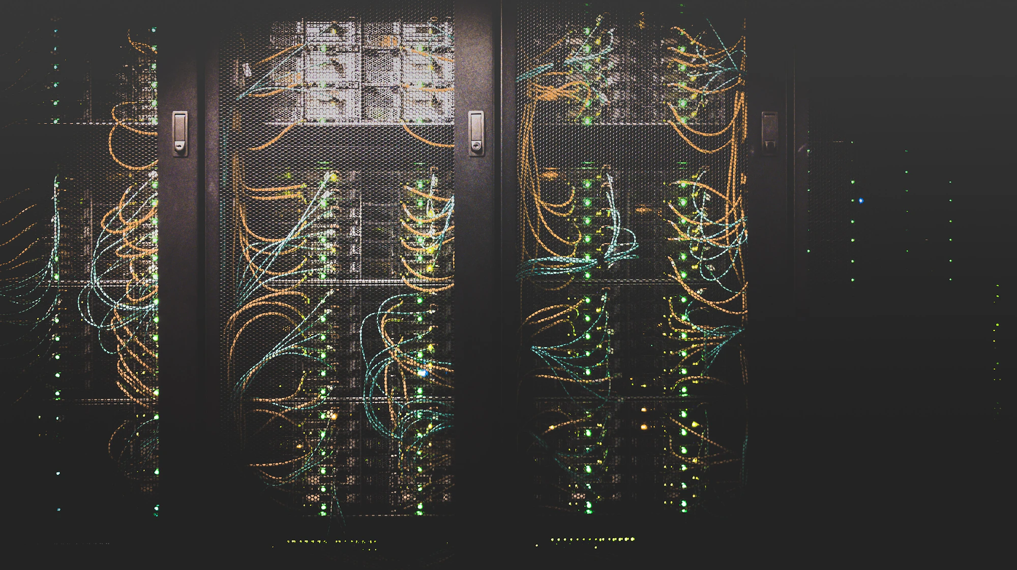 Corredor de um data center com racks iluminados por luz azul ao fundo